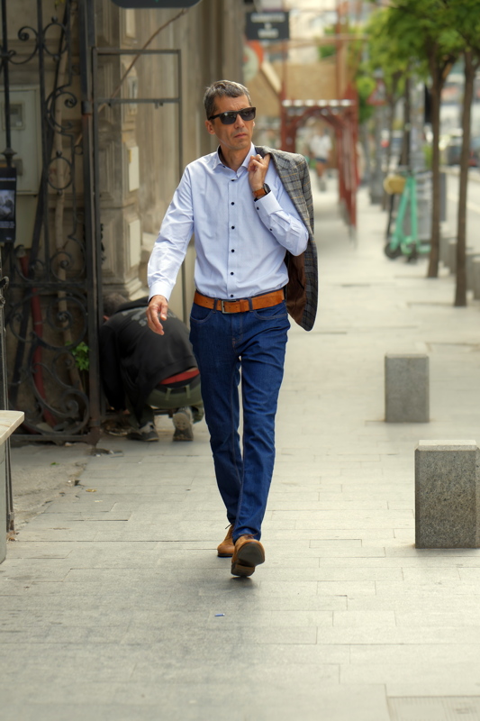 Man dressed in a smart-casual ensemble featuring a patterned button-down shirt and tailored trousers